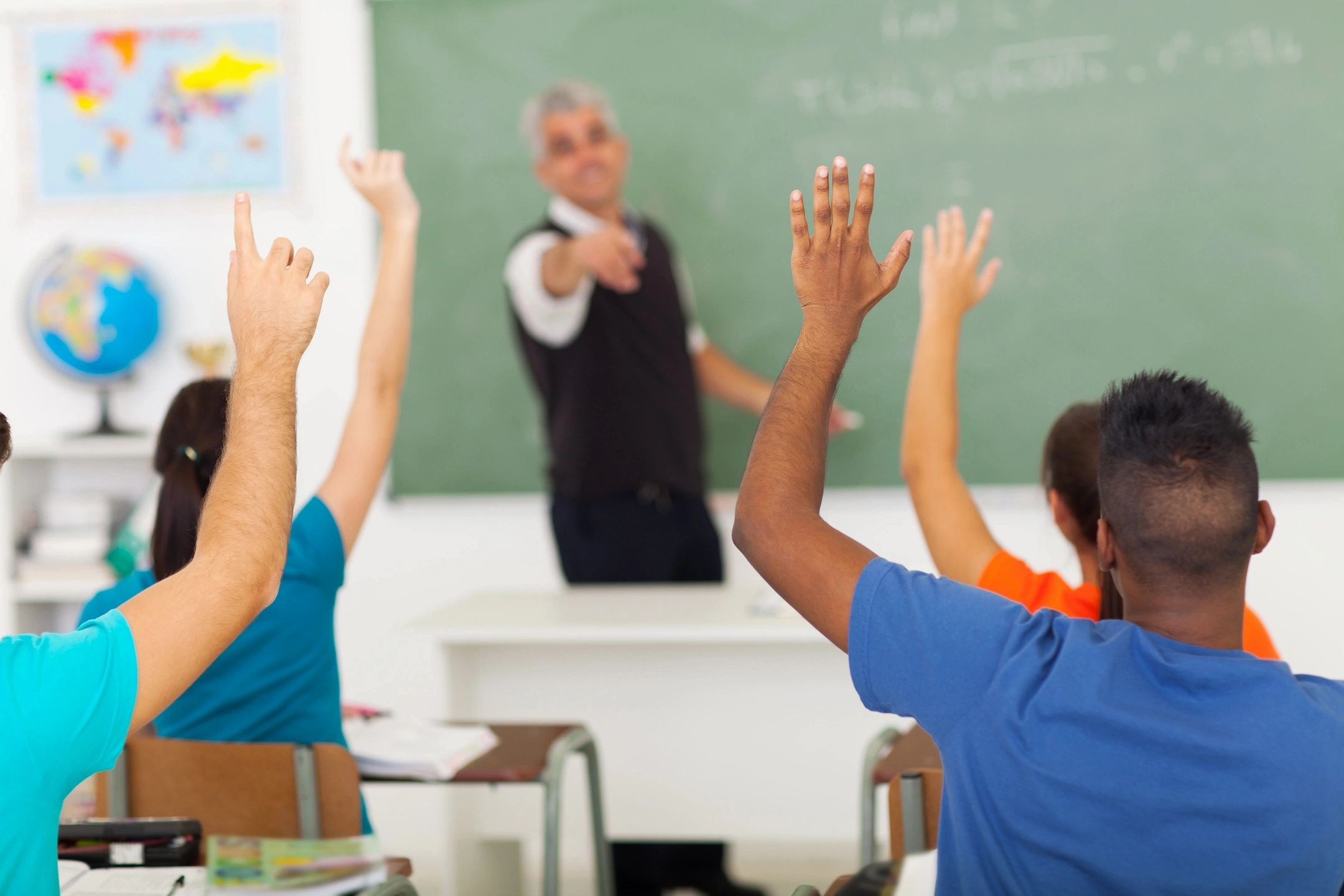 Kids raising hands in school